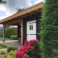 Houten veranda met eiken staanders aan een tuinhuis